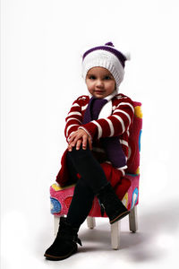 Cute boy wearing hat sitting against white background