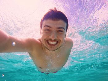 Portrait of smiling young woman swimming in pool