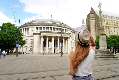 Traveler girl walking in st peter square in manchester city, united kingdom