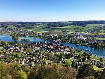 High angle view of river amidst field against clear blue sky