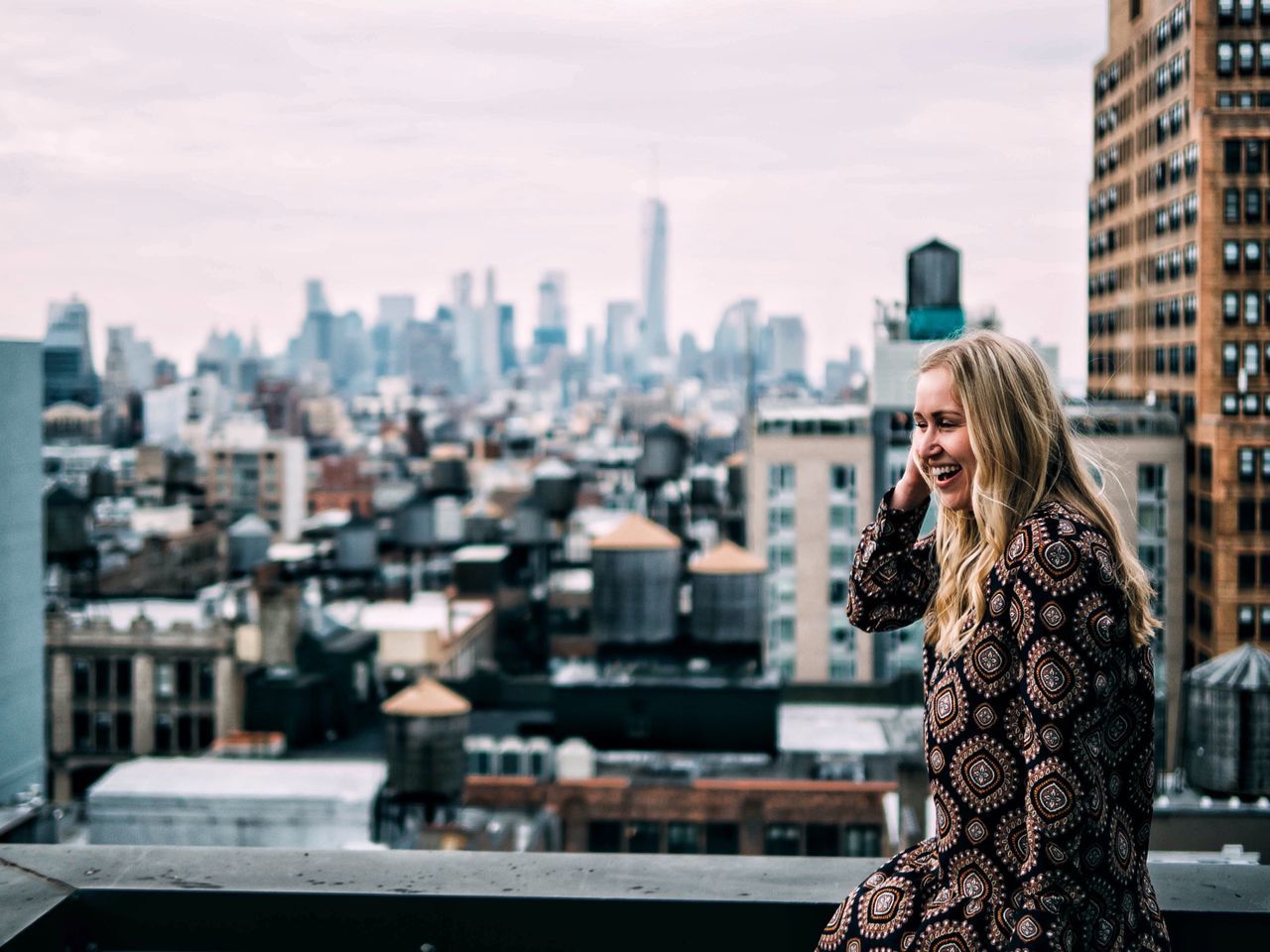 building exterior, city, architecture, built structure, cityscape, lifestyles, young adult, rear view, leisure activity, focus on foreground, city life, standing, young women, person, casual clothing, waist up, three quarter length, sky