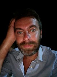 Portrait of young man against black background