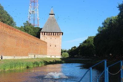 View of building by river against sky