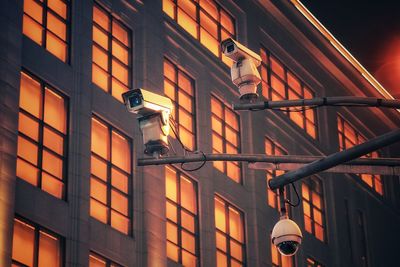 Low angle view of security cameras against building