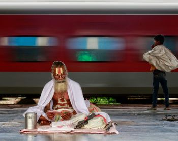 Full length rear view of man sitting on train