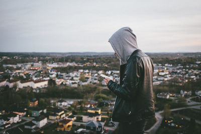 Rear view of man standing in front of townscape