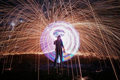 Full length of woman standing in lights at night