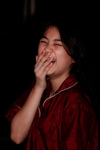 Portrait of a beautiful young woman with red eyes closed