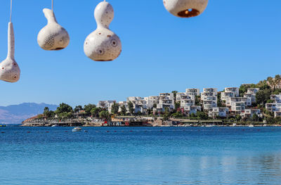 Panoramic view of sea and buildings against clear blue sky