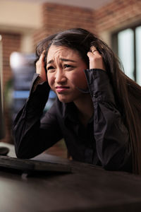 Young woman using mobile phone at table