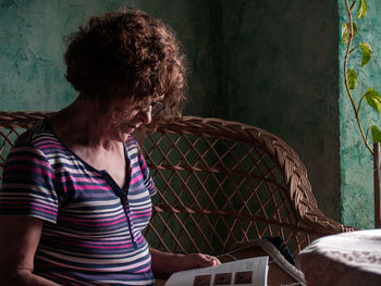 Woman reading book white sitting on seat at home