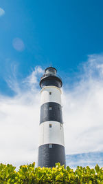 Low angle view of lighthouse by building against sky