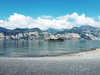 Scenic view of lake and mountains against blue sky