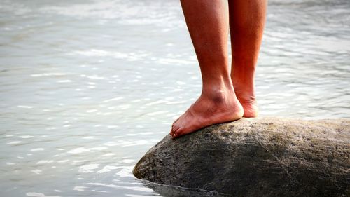 Low section of man standing on beach