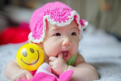 Cute baby girl with toy on bed