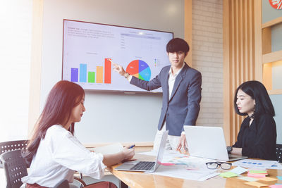 Business colleagues working together at desk in office