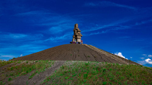 Low angle view of landscape against blue sky