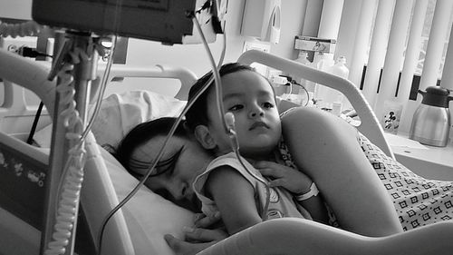 Mother with son on bed in hospital