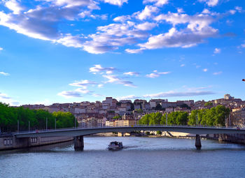 Bridge over river against buildings in city