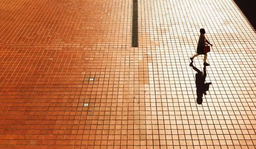 High angle view of woman walking on tiled ground