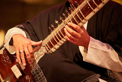 A man playing an indian sitar, close-up