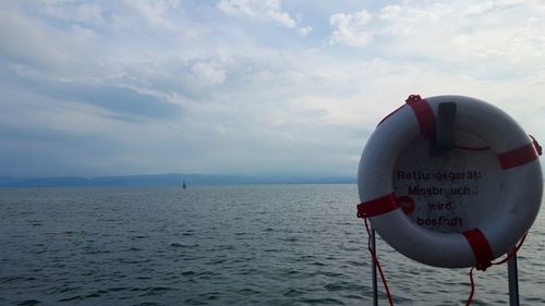 Rear view of man on boat at beach against sky