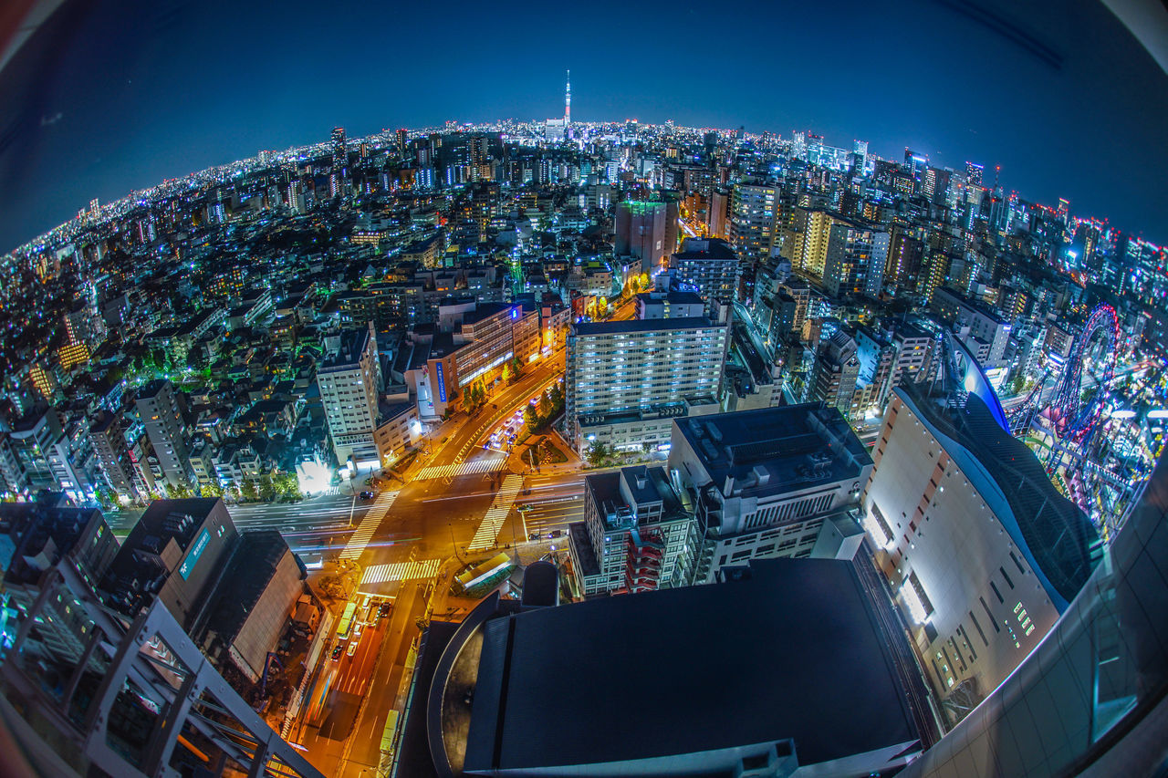 HIGH ANGLE VIEW OF ILLUMINATED CITY BUILDINGS AT NIGHT