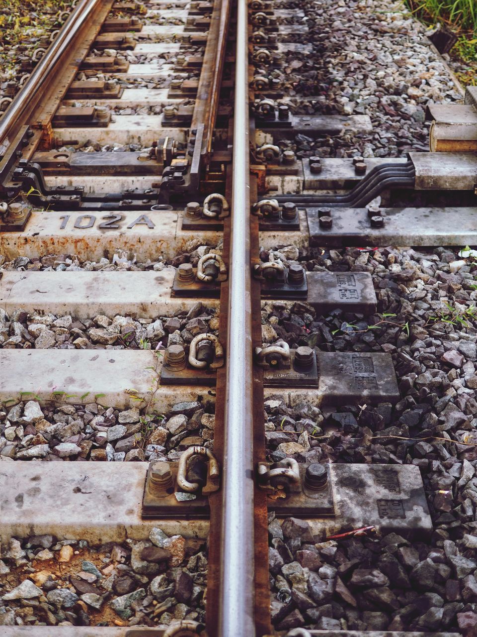 HIGH ANGLE VIEW OF RAILROAD TRACKS AT RAILWAY STATION