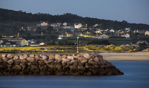 Scenic view of sea by town against sky