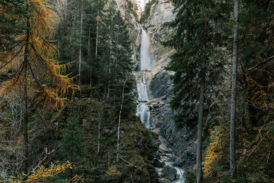 Beautiful waterfall in moody forest in autumn in gozd martuljek in slovenia