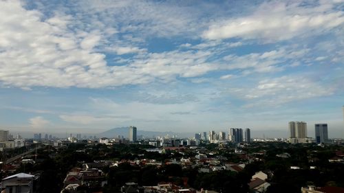 Aerial view of buildings in city against sky