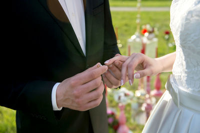 Midsection of bridegroom holding hands