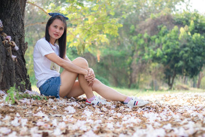 Portrait of smiling young woman sitting on land