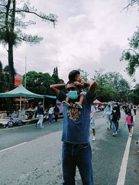 People on street against sky in city