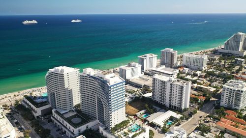 High angle view of buildings by sea against sky