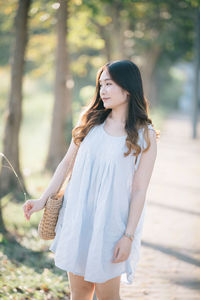 Beautiful woman standing against trees in forest