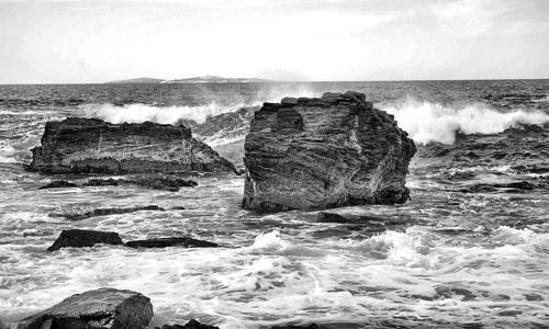 Scenic view of sea by cliff against sky