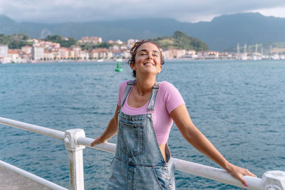 Portrait of young woman standing against sea