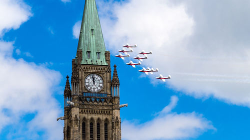 Low angle view of clock tower against cloudy sky
