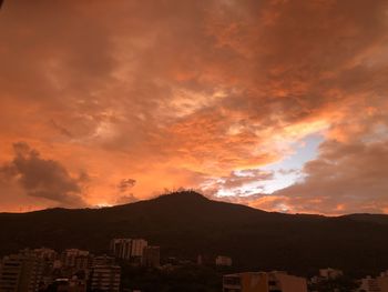 Scenic view of dramatic sky over city during sunset