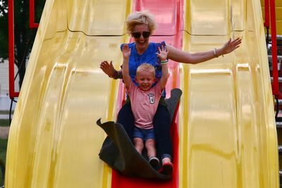 Full length portrait of happy boy on slide