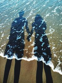 Low section of people standing on beach