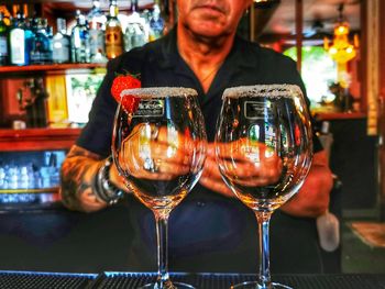 Reflection of man drinking glass on table in restaurant