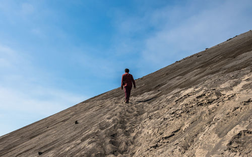 Low angle view of man on mountain against sky