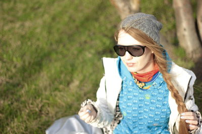 Portrait of young woman wearing sunglasses standing outdoors