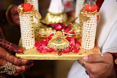 Close-up of bride and groom holding religious equipment during wedding ceremony