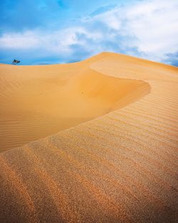 Sand dunes in desert against sky