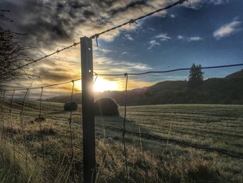 Scenic view of field against sky at sunset