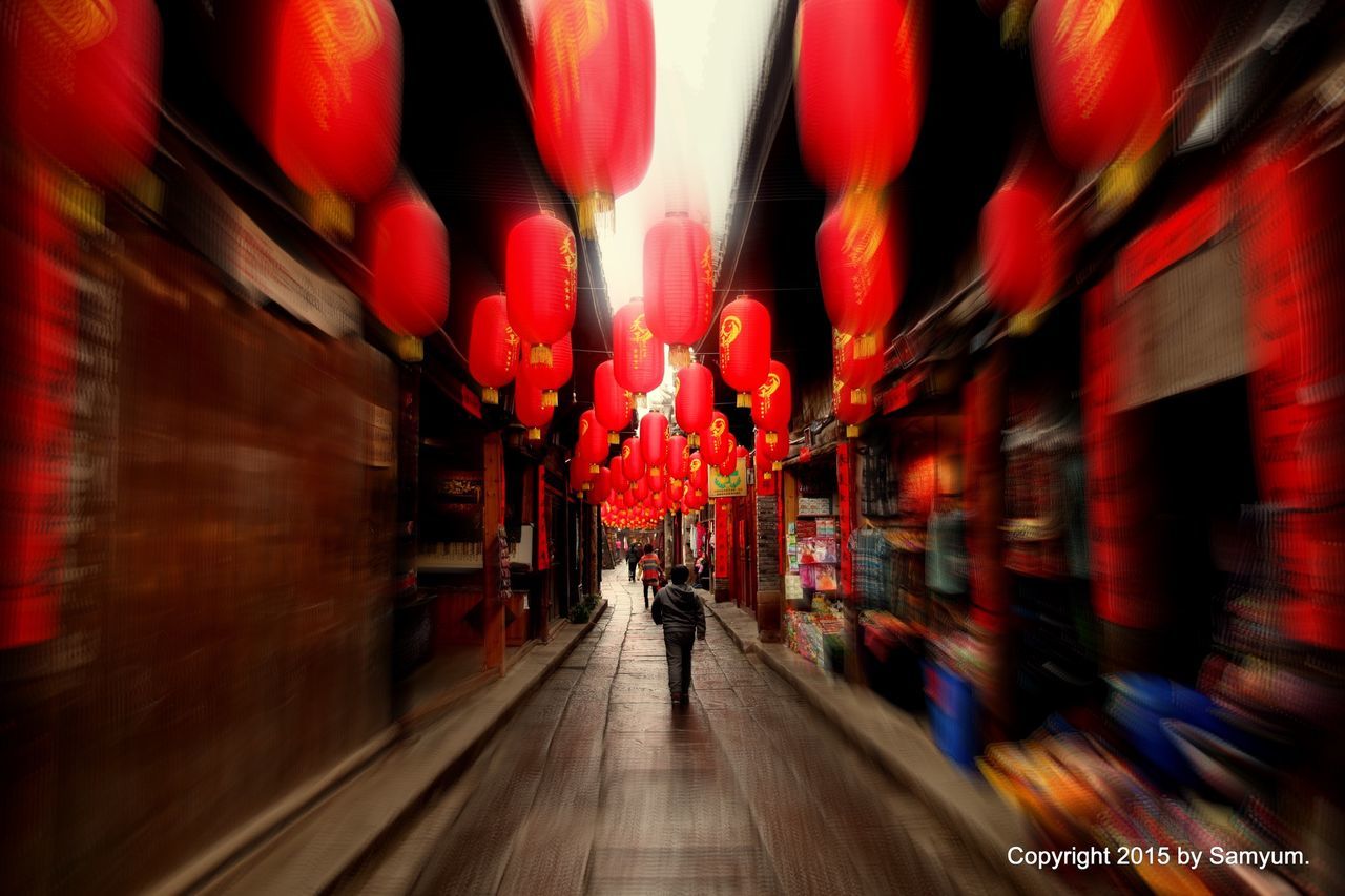 illuminated, person, men, walking, architecture, lifestyles, built structure, red, the way forward, leisure activity, large group of people, night, indoors, rear view, lighting equipment, incidental people, building exterior, decoration, city life