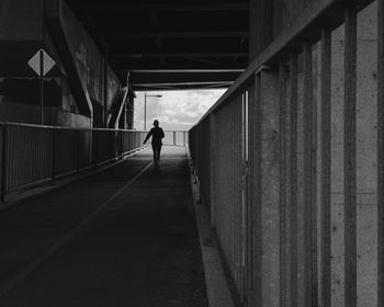Rear view of man walking on footpath